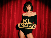 Woman in black bodysuit holding "KL Malay" sign